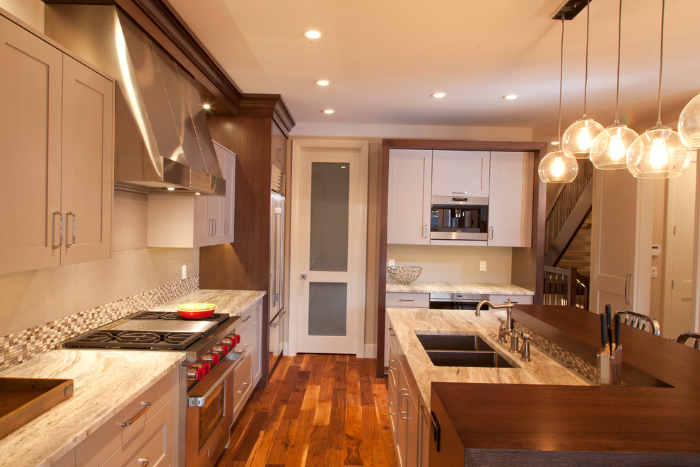 Example of a mid-sized transitional l-shaped dark wood floor eat-in kitchen design in Calgary with beige cabinets, stainless steel appliances and an island