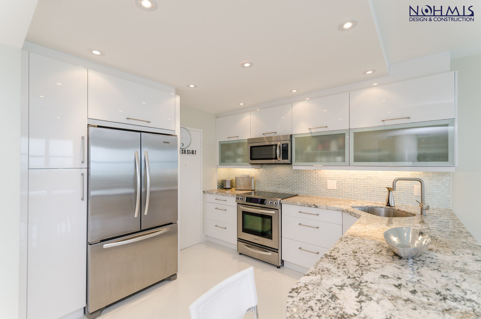 Design ideas for a mid-sized contemporary galley eat-in kitchen in Miami with a double-bowl sink, recessed-panel cabinets, white cabinets, granite benchtops, beige splashback, mosaic tile splashback, stainless steel appliances, marble floors and with island.