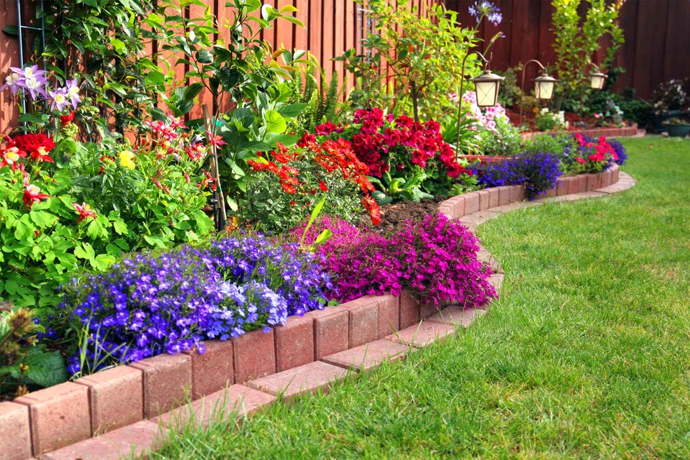 Inspiration for a mid-sized transitional full sun backyard brick formal garden in Calgary.