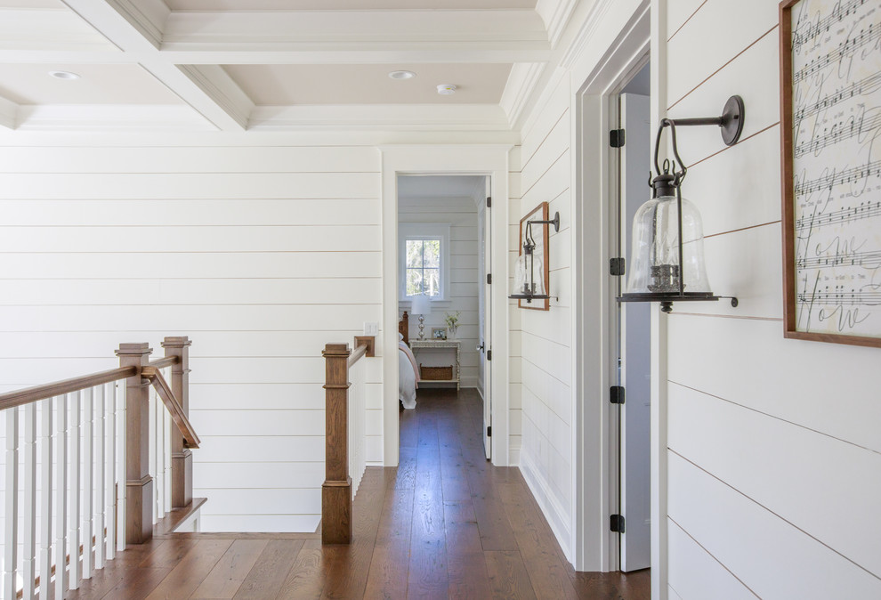 Photo of a country hallway in Jacksonville with white walls, medium hardwood floors and brown floor.