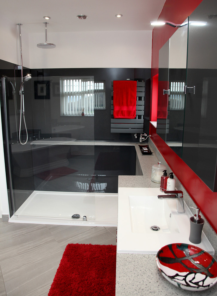 This is an example of a mid-sized contemporary 3/4 bathroom in Other with flat-panel cabinets, grey cabinets, a freestanding tub, an open shower, a one-piece toilet, red walls, a vessel sink, solid surface benchtops, grey floor, an open shower and grey benchtops.