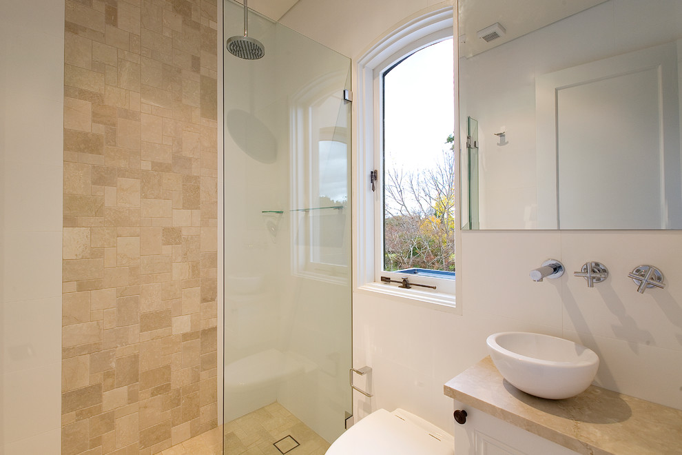 This is an example of a transitional bathroom in Sydney with a vessel sink, a wall-mount toilet and stone tile.
