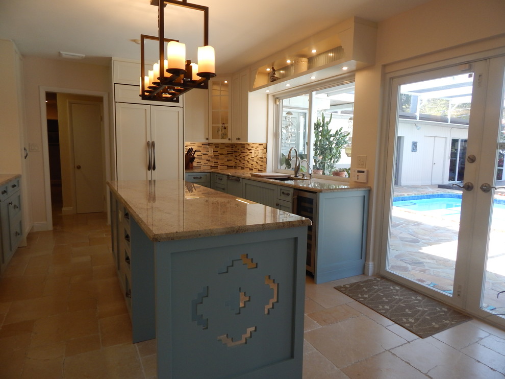 Design ideas for a mid-sized country galley separate kitchen in Miami with an undermount sink, shaker cabinets, blue cabinets, granite benchtops, multi-coloured splashback, matchstick tile splashback, stainless steel appliances, limestone floors, with island and beige floor.