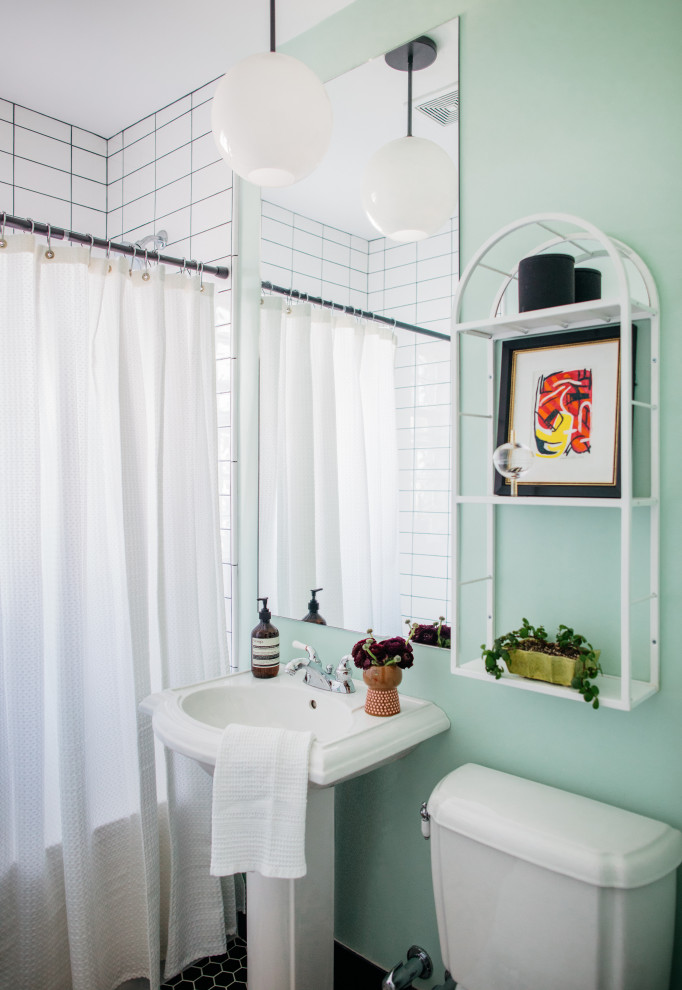 Eklektisk inredning av ett litet badrum, med en dusch/badkar-kombination, gröna väggar, klinkergolv i keramik, ett piedestal handfat, svart golv, dusch med duschdraperi, ett badkar i en alkov och vit kakel