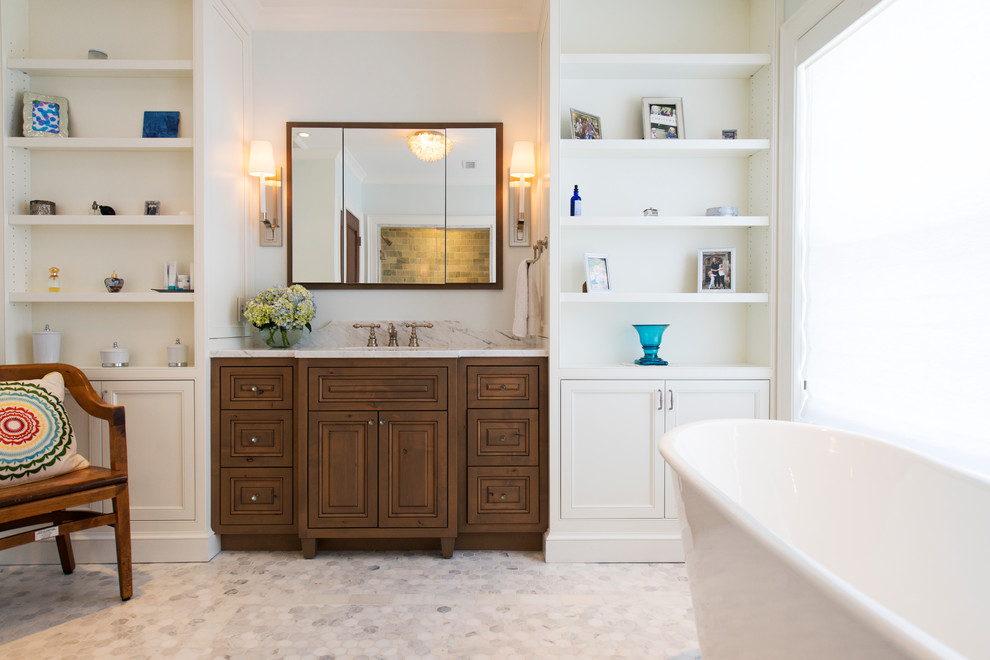 This is an example of a transitional master bathroom in DC Metro with raised-panel cabinets, medium wood cabinets, a freestanding tub, an alcove shower, white walls, an undermount sink, grey floor and white benchtops.
