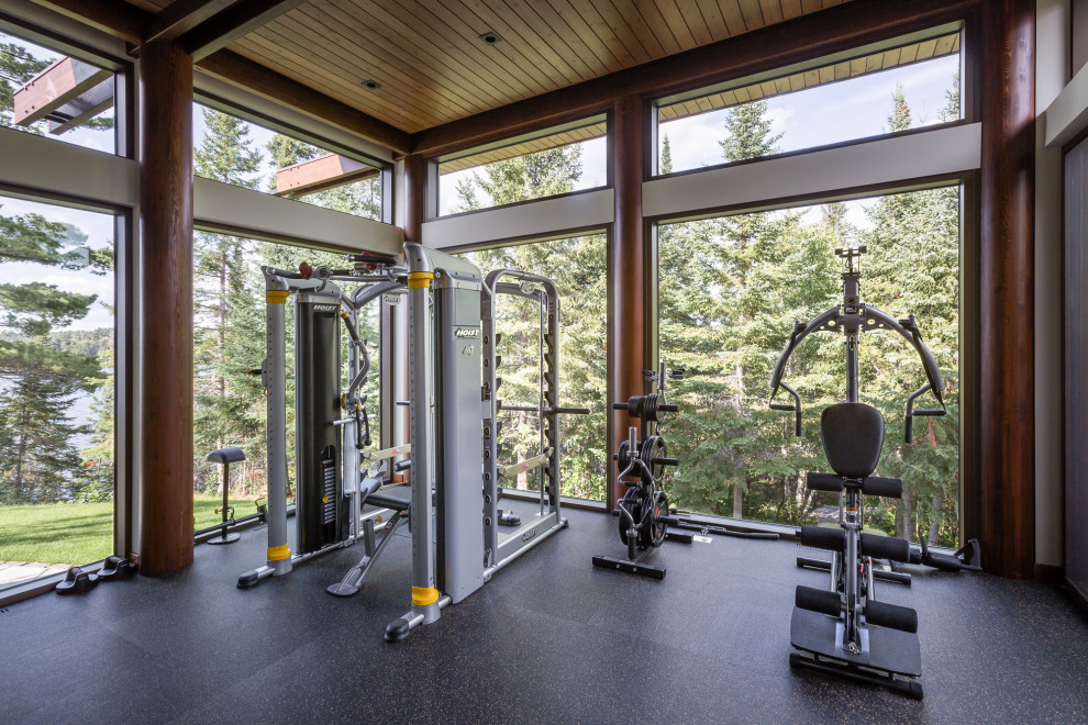 Inspiration for a country home gym in Other with black floor and wood.