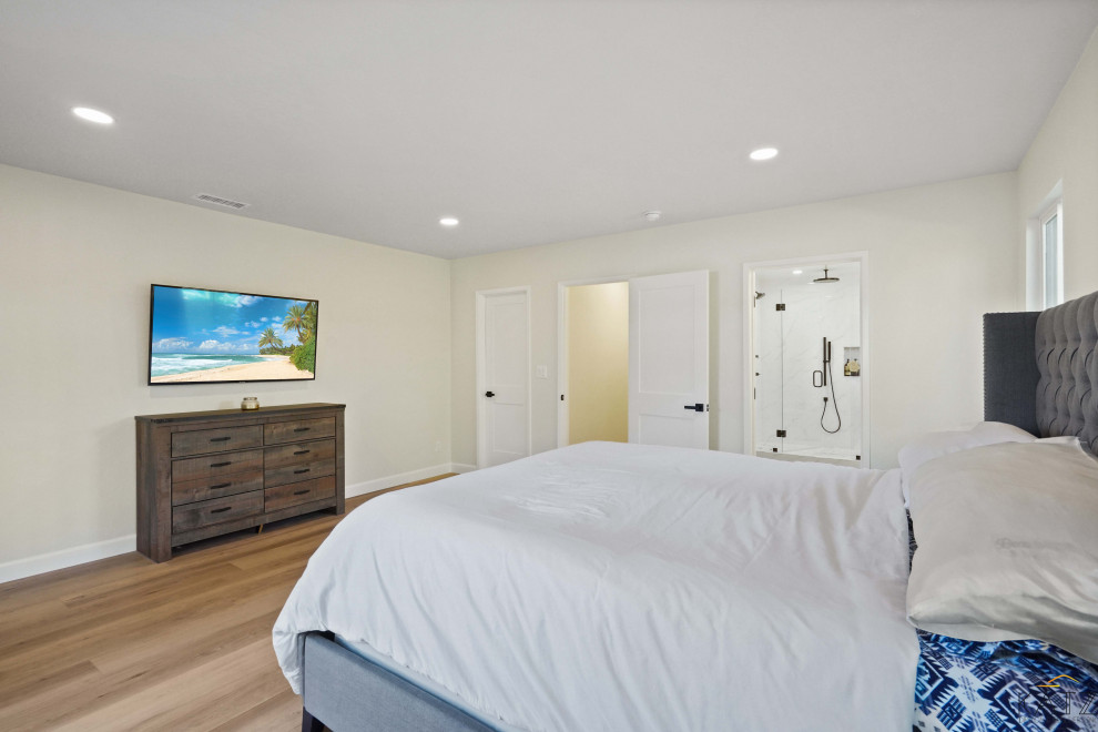 Пример оригинального дизайна: большая гостевая спальня (комната для гостей) с бежевыми стенами, паркетным полом среднего тона и оранжевым полом