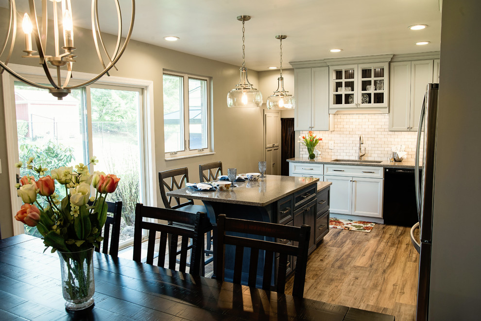 Eat-in kitchen - mid-sized transitional l-shaped vinyl floor eat-in kitchen idea with an undermount sink, recessed-panel cabinets, gray cabinets, quartz countertops, white backsplash, marble backsplash, stainless steel appliances and an island