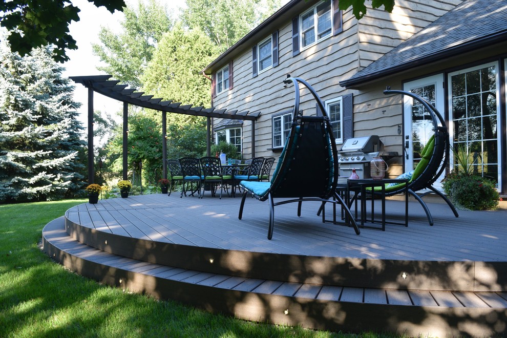 Inspiration for a large modern backyard deck in Toronto with a container garden and a pergola.