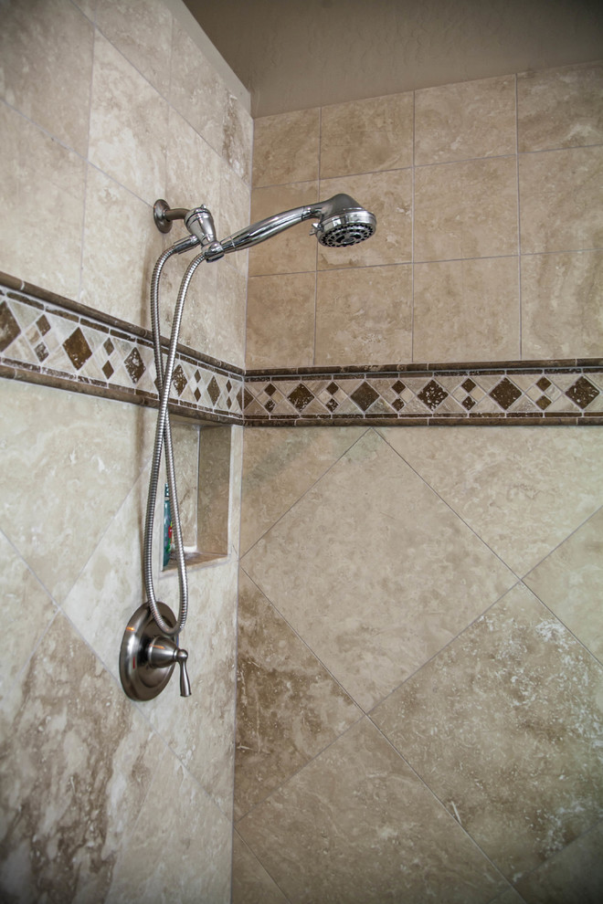 Example of a large transitional master ceramic tile drop-in bathtub design in Phoenix with raised-panel cabinets, light wood cabinets, beige walls, an undermount sink and granite countertops