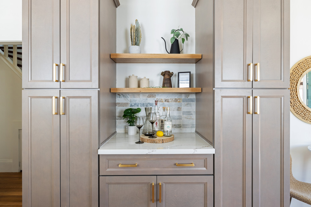 This is an example of a mid-sized transitional galley separate kitchen in San Francisco with an undermount sink, recessed-panel cabinets, beige cabinets, quartz benchtops, beige splashback, marble splashback, stainless steel appliances, light hardwood floors, no island, beige floor and white benchtop.
