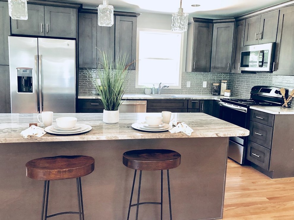 Mid-sized transitional l-shaped eat-in kitchen in Baltimore with an undermount sink, shaker cabinets, grey cabinets, granite benchtops, grey splashback, mosaic tile splashback, stainless steel appliances, light hardwood floors, with island, multi-coloured floor and multi-coloured benchtop.