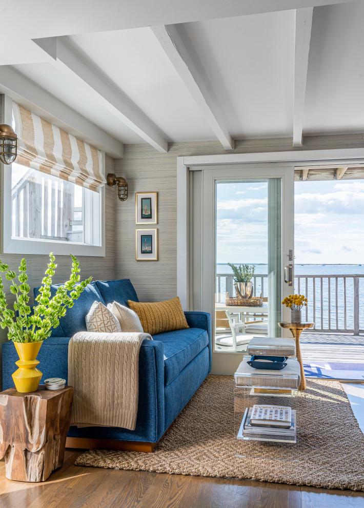 Идея дизайна: маленькая гостиная комната в морском стиле с бежевыми стенами, обоями на стенах, темным паркетным полом, коричневым полом, балками на потолке и синим диваном для на участке и в саду