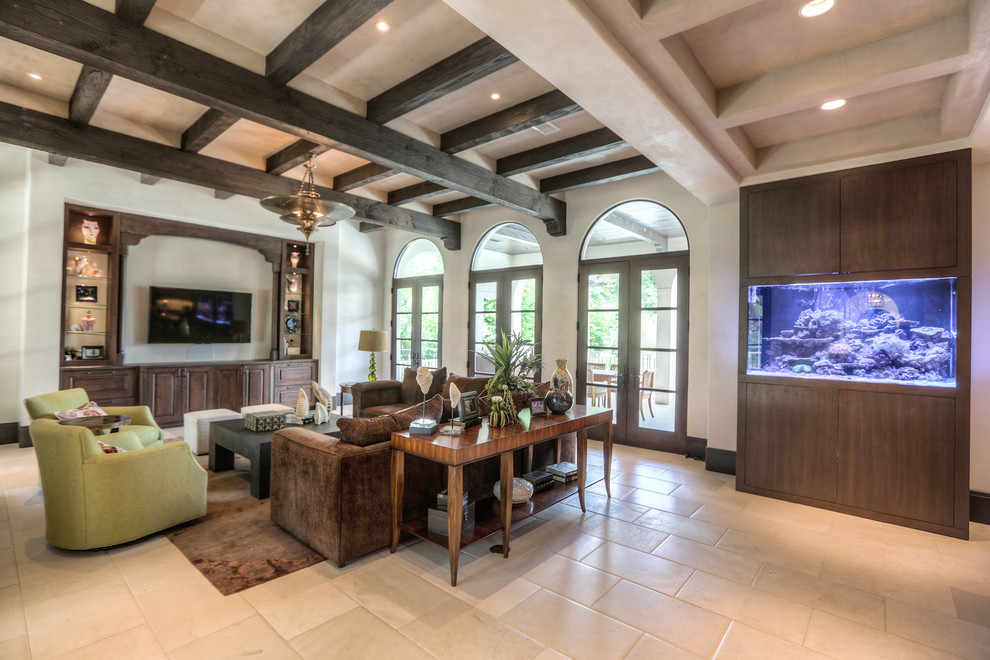 Large mediterranean formal enclosed living room in Houston with white walls, limestone floors, no fireplace, a wall-mounted tv and beige floor.