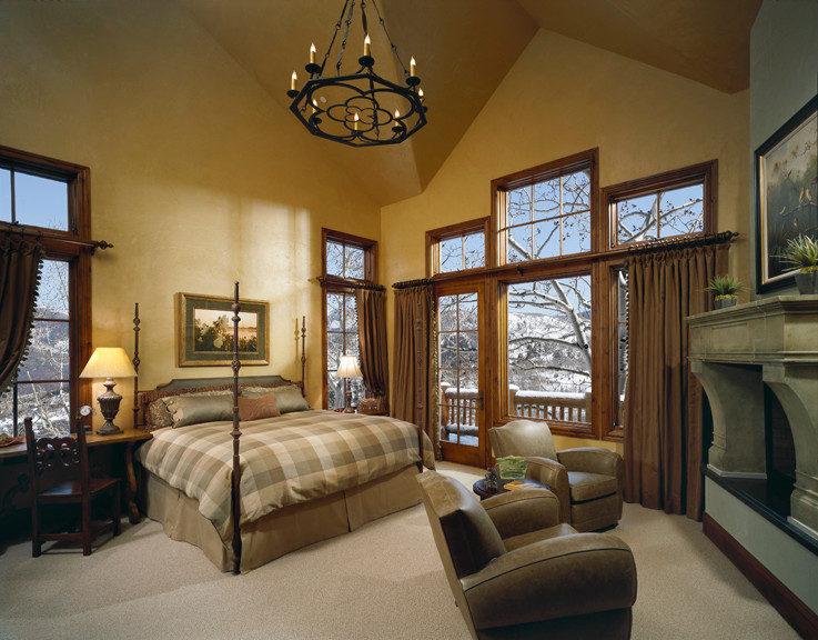 Photo of a large traditional guest bedroom in Phoenix with yellow walls, carpet, a standard fireplace, a stone fireplace surround and beige floor.