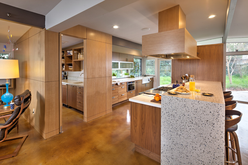 Design ideas for a mid-sized midcentury galley eat-in kitchen in Sacramento with a farmhouse sink, glass-front cabinets, medium wood cabinets, quartz benchtops, stainless steel appliances, concrete floors, with island and brown floor.