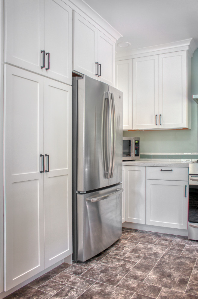 Enclosed kitchen - small craftsman u-shaped vinyl floor and gray floor enclosed kitchen idea in Other with an undermount sink, shaker cabinets, white cabinets, quartz countertops, green backsplash, ceramic backsplash, stainless steel appliances and gray countertops