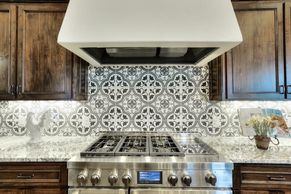 Example of a huge transitional u-shaped dark wood floor eat-in kitchen design in Austin with a farmhouse sink, recessed-panel cabinets, dark wood cabinets, granite countertops, multicolored backsplash, porcelain backsplash, stainless steel appliances and two islands