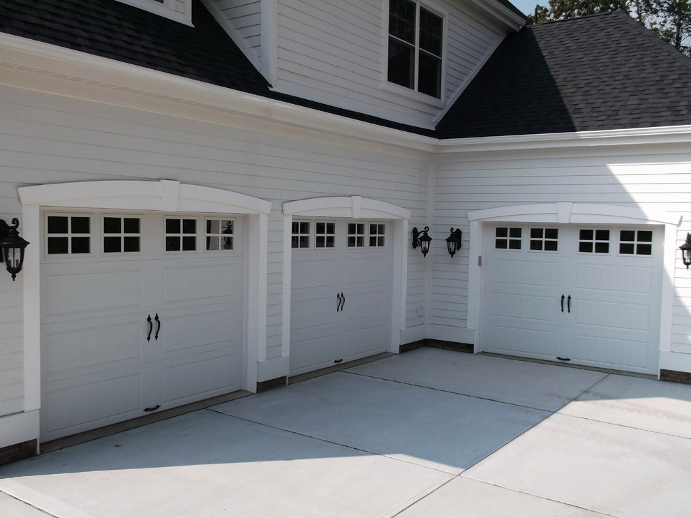 Design ideas for a large transitional attached three-car garage in Other.