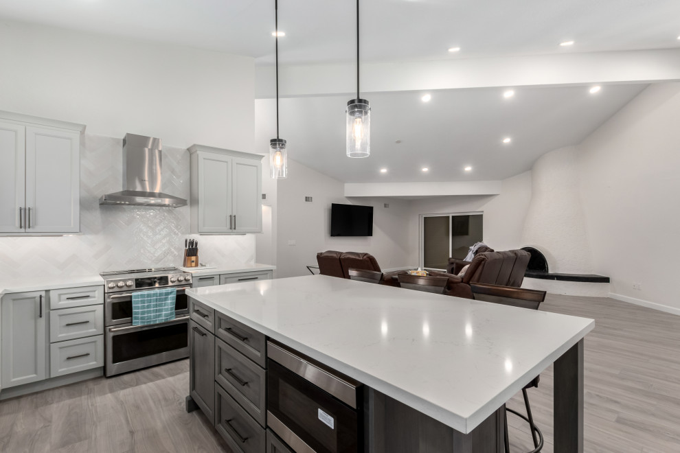Mid-sized transitional porcelain tile and gray floor eat-in kitchen photo in Phoenix with an undermount sink, shaker cabinets, gray cabinets, quartz countertops, white backsplash, subway tile backsplash, stainless steel appliances, an island and white countertops