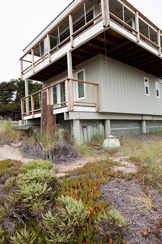 Large beach style two-storey green exterior in San Francisco with vinyl siding and a hip roof.