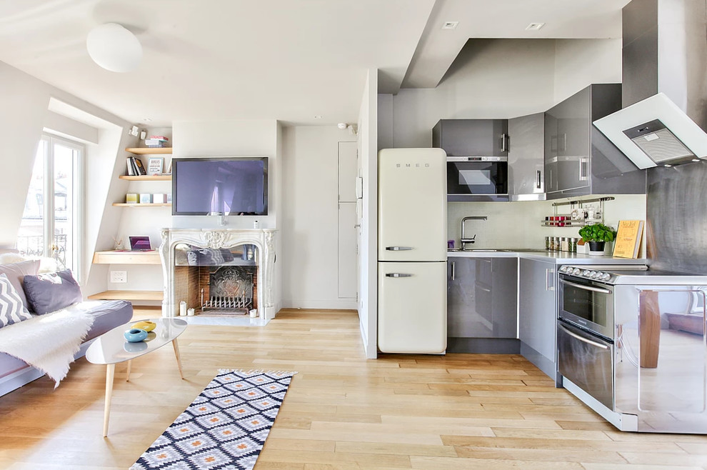Idée de décoration pour cuisine américaine in L With un évier encastré, des portes de placard grises, un plan de travail en surface solide, une crédence blanche, une crédence en mosaïque, un électroménager en acier inoxydable, parquet clair, aucun îlot, un sol marron and un plan de travail gris.