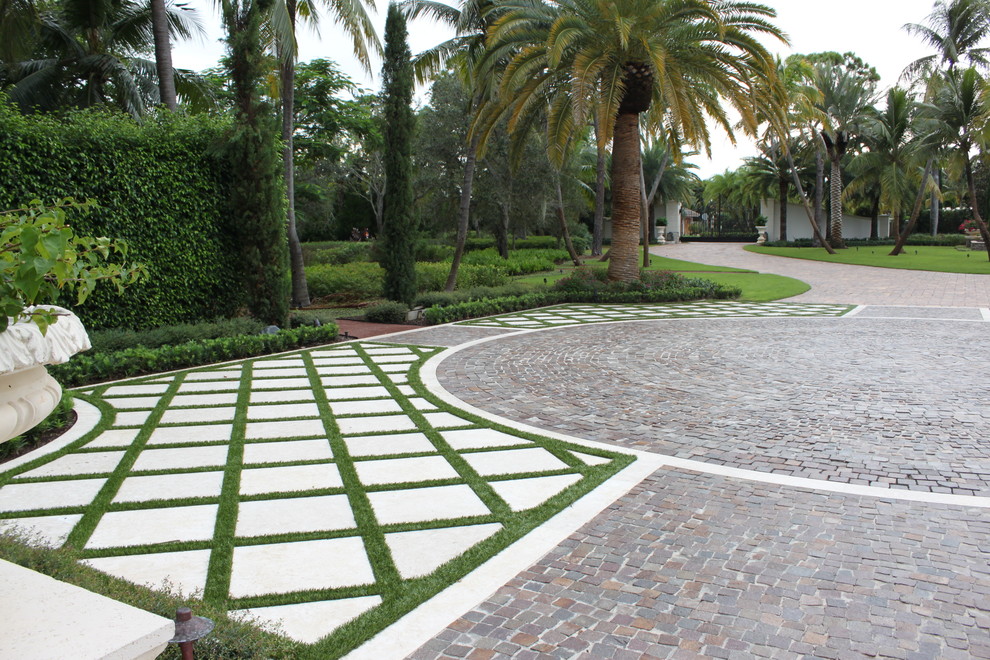 Design ideas for a large modern front yard partial sun driveway in Miami with a garden path and brick pavers.