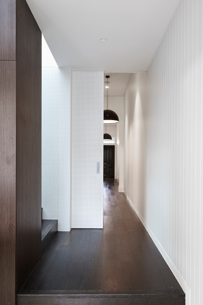This is an example of a mid-sized contemporary hallway in Melbourne with white walls and dark hardwood floors.