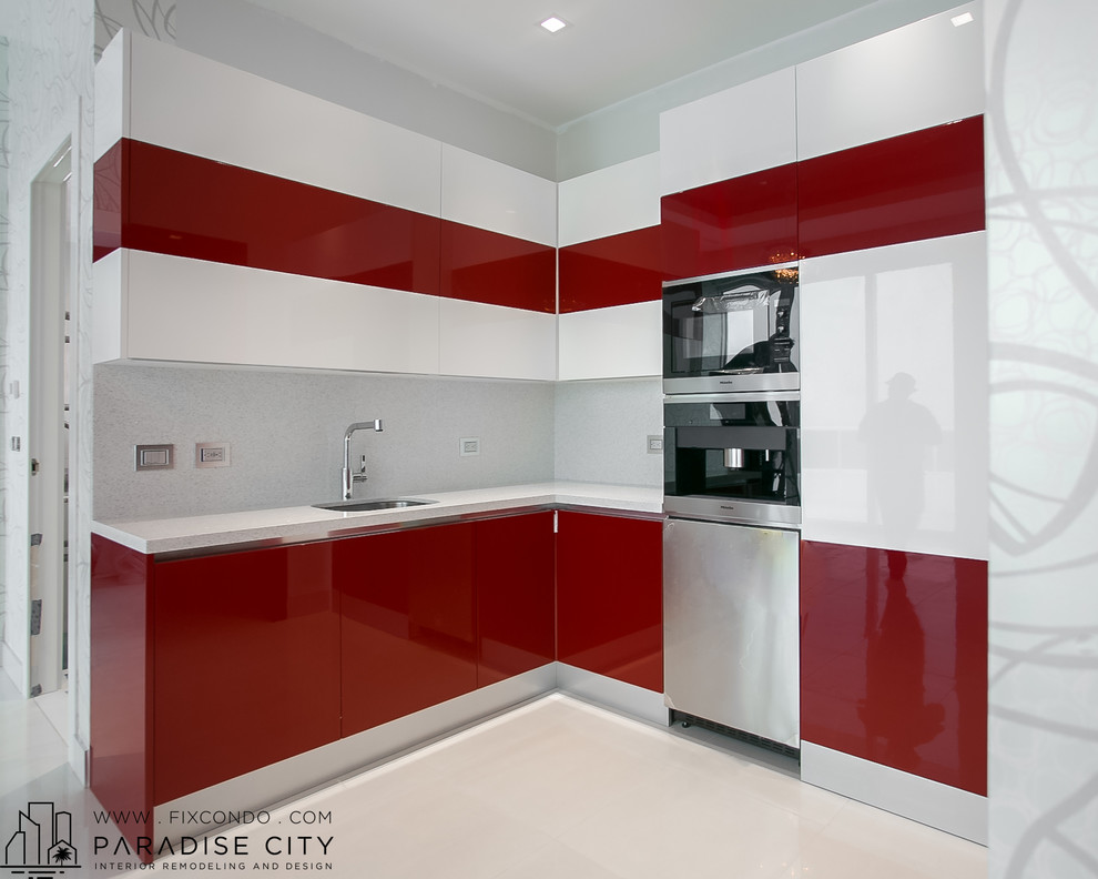 Photo of a small contemporary eat-in kitchen in Miami with a single-bowl sink, flat-panel cabinets, red cabinets, granite benchtops, grey splashback, stone slab splashback, ceramic floors and no island.