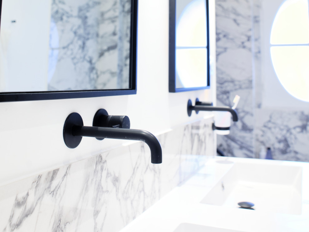 Modernes Duschbad mit schwarz-weißen Fliesen, Marmorfliesen, weißer Wandfarbe, hellem Holzboden, Wandwaschbecken, Doppelwaschbecken und Steinwänden in Bordeaux