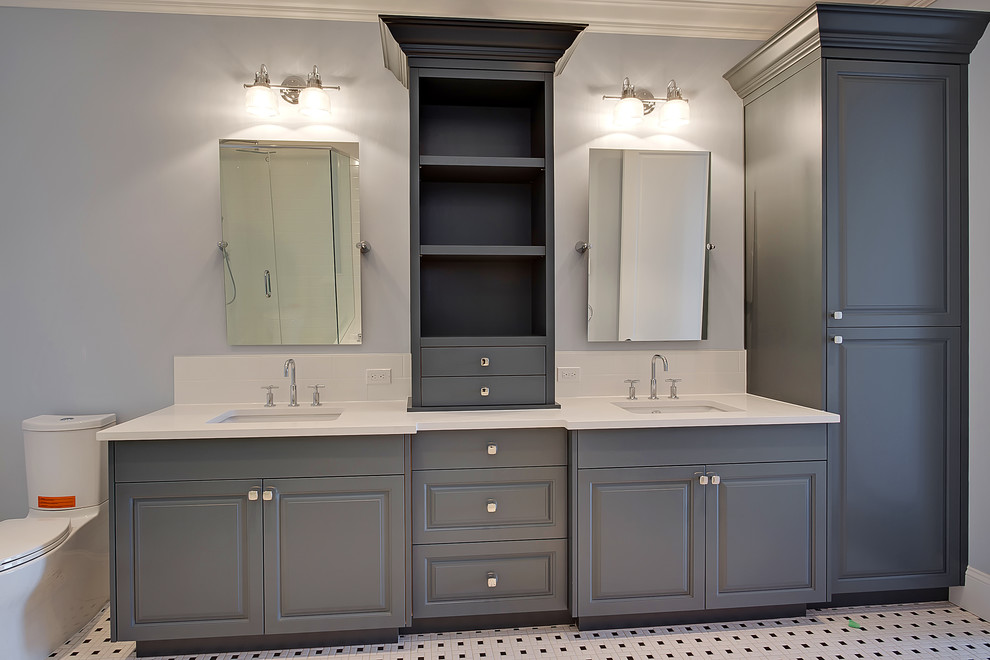 Inspiration for a mid-sized transitional master bathroom in Calgary with raised-panel cabinets, grey cabinets, a corner shower, a two-piece toilet, white tile, subway tile, white walls, porcelain floors, an undermount sink, solid surface benchtops, multi-coloured floor and a hinged shower door.