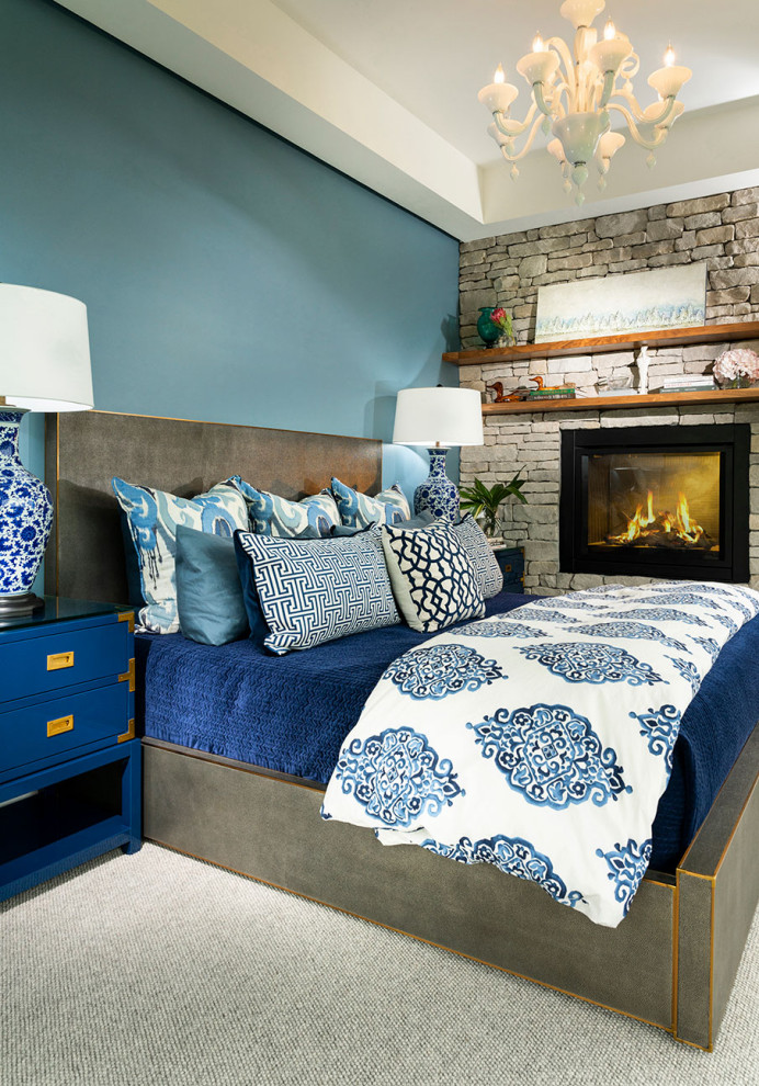 Идея дизайна: большая хозяйская спальня в стиле модернизм с синими стенами, ковровым покрытием, двусторонним камином, фасадом камина из каменной кладки, серым полом и многоуровневым потолком
