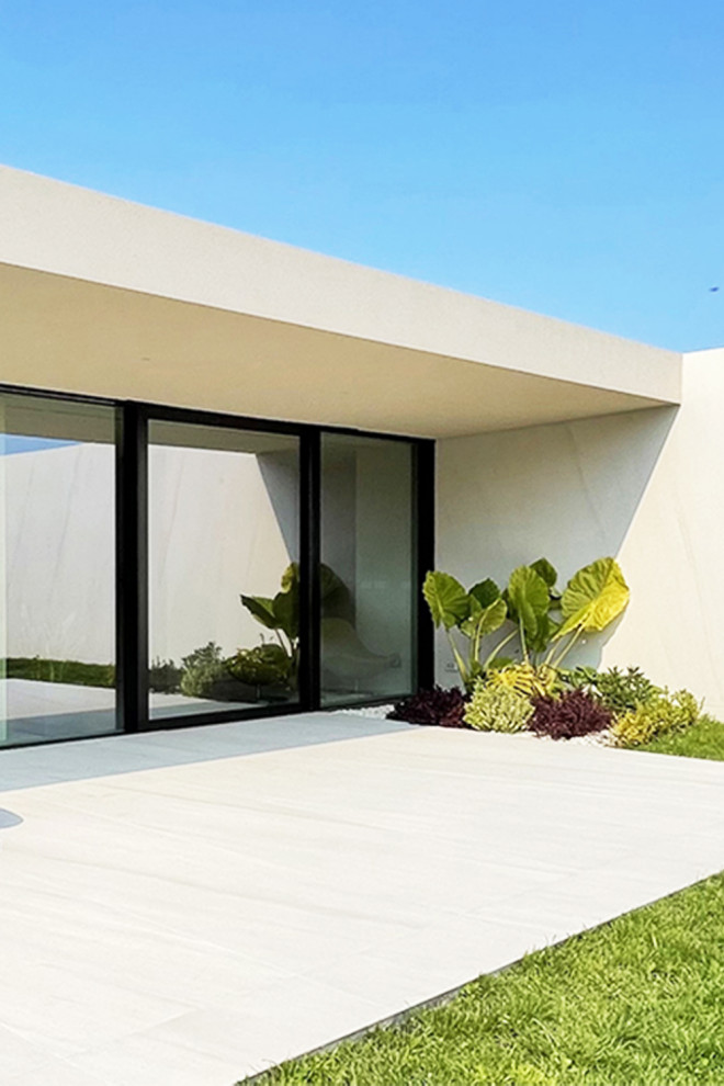 Свежая идея для дизайна: огромный, одноэтажный, белый дом в стиле модернизм с облицовкой из камня и плоской крышей - отличное фото интерьера