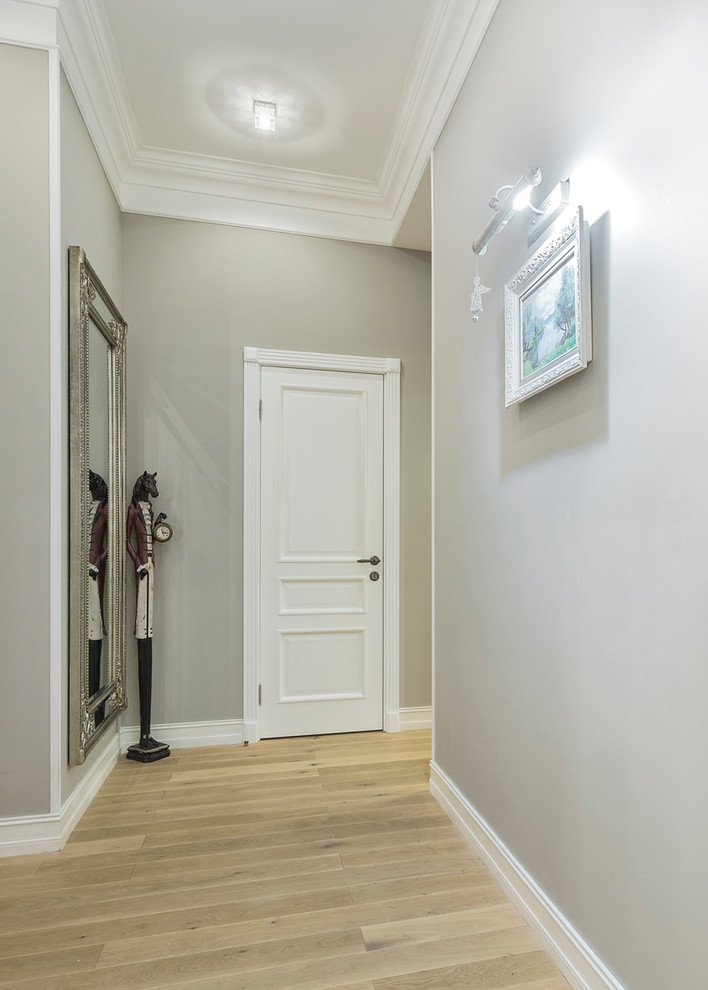 Traditional hallway in Moscow with grey walls and light hardwood floors.