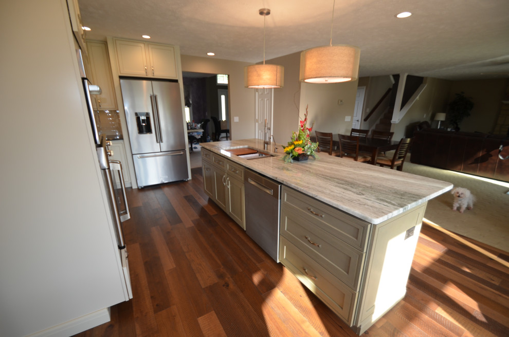 Example of a mid-sized transitional u-shaped medium tone wood floor and brown floor eat-in kitchen design with an undermount sink, raised-panel cabinets, beige cabinets, granite countertops, multicolored backsplash, mosaic tile backsplash, stainless steel appliances, an island and multicolored countertops