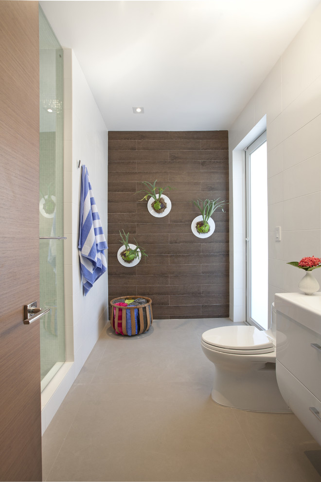 Inspiration for a modern bathroom in Miami with white cabinets, an alcove shower, a one-piece toilet and brown tile.