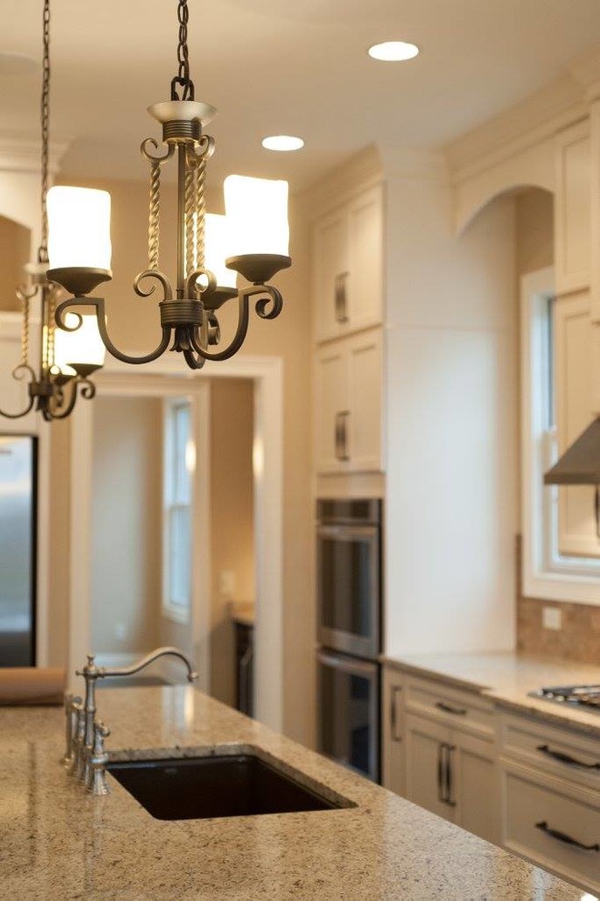 Transitional l-shaped kitchen photo in Indianapolis with an undermount sink, shaker cabinets, white cabinets, granite countertops, beige backsplash, mosaic tile backsplash, stainless steel appliances and an island