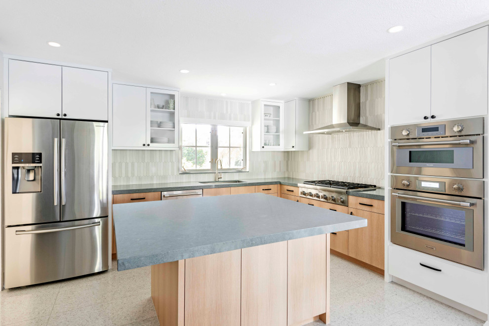 Mid-sized minimalist l-shaped white floor eat-in kitchen photo in Tampa with a single-bowl sink, white cabinets, multicolored backsplash, stainless steel appliances, an island and blue countertops