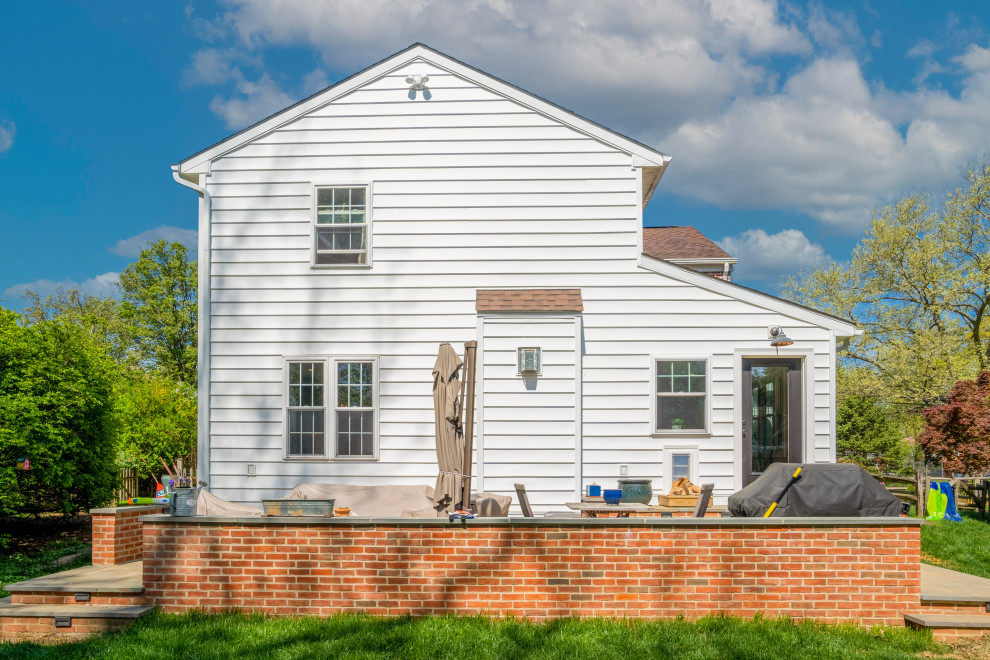 Idee per la facciata di una casa bianca country a un piano di medie dimensioni con rivestimento in vinile, copertura a scandole, tetto marrone e pannelli sovrapposti