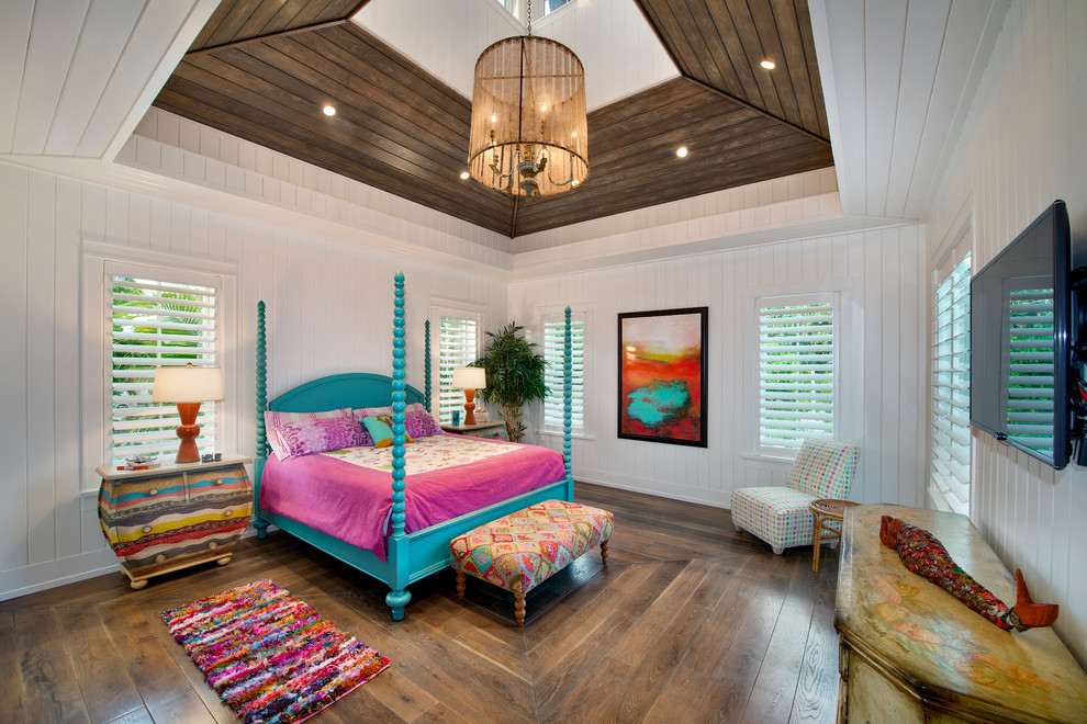 Photo of a large tropical master bedroom in Miami with white walls and medium hardwood floors.