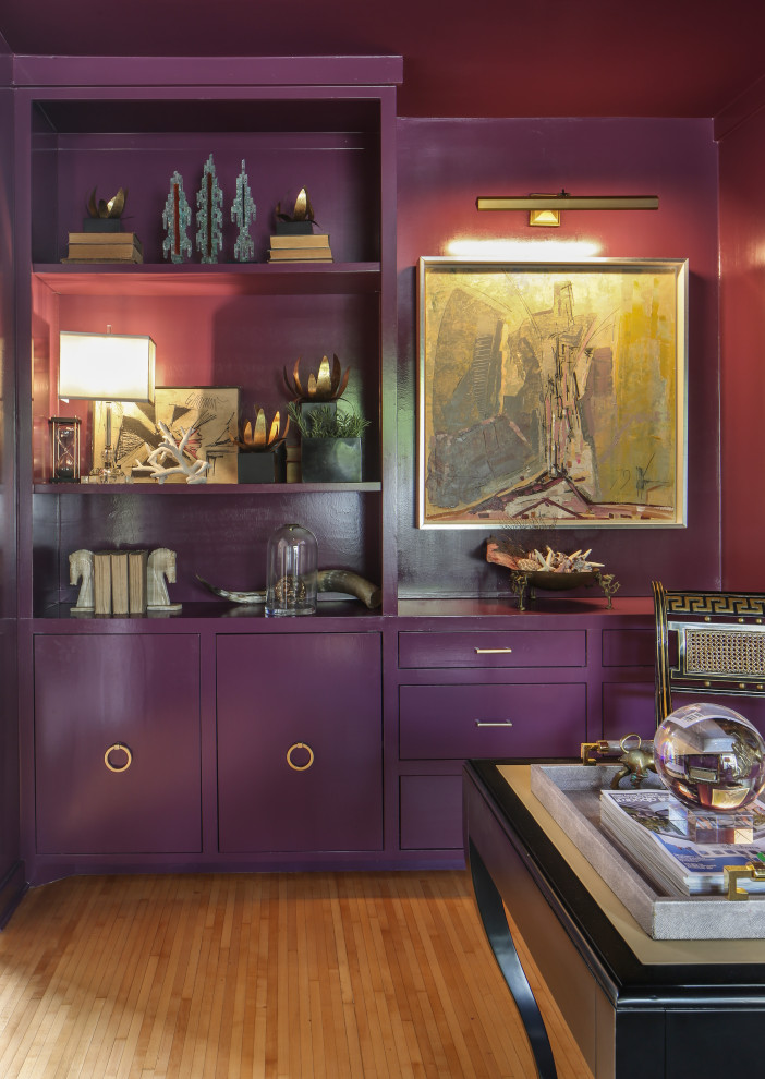 This is an example of a large retro study in New Orleans with purple walls, medium hardwood flooring, a freestanding desk and brown floors.