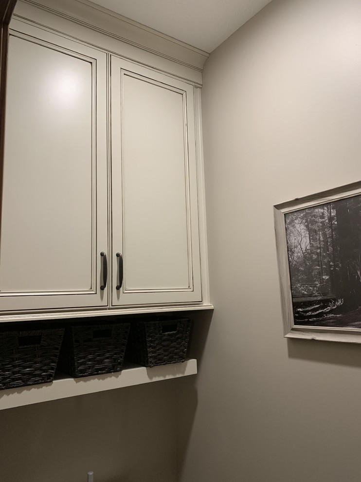 Large transitional master beige tile and ceramic tile linoleum floor and brown floor home design photo with recessed-panel cabinets, white cabinets, a two-piece toilet, beige walls, an undermount sink, granite countertops, a hinged shower door and multicolored countertops
