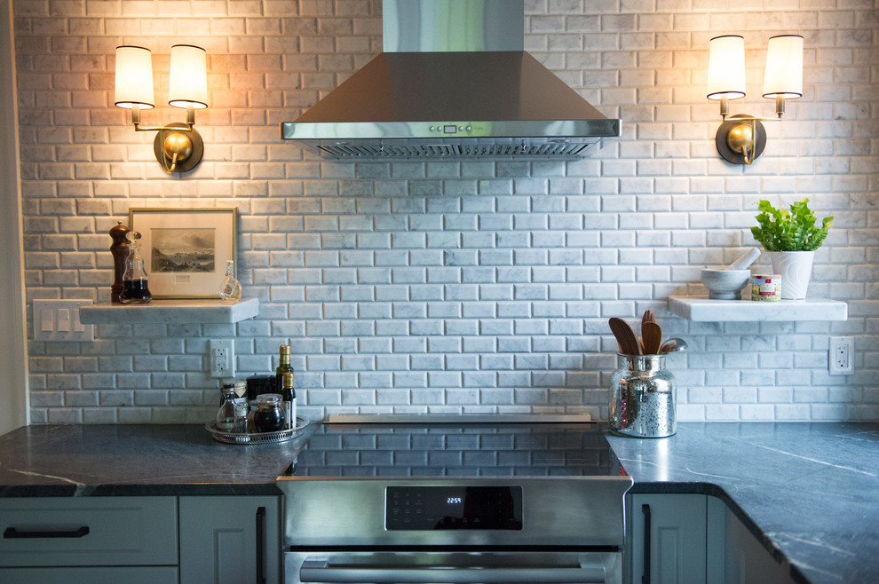 Mid-sized transitional l-shaped dark wood floor eat-in kitchen photo with an undermount sink, soapstone countertops, gray backsplash, stone tile backsplash, stainless steel appliances, an island, shaker cabinets and white cabinets