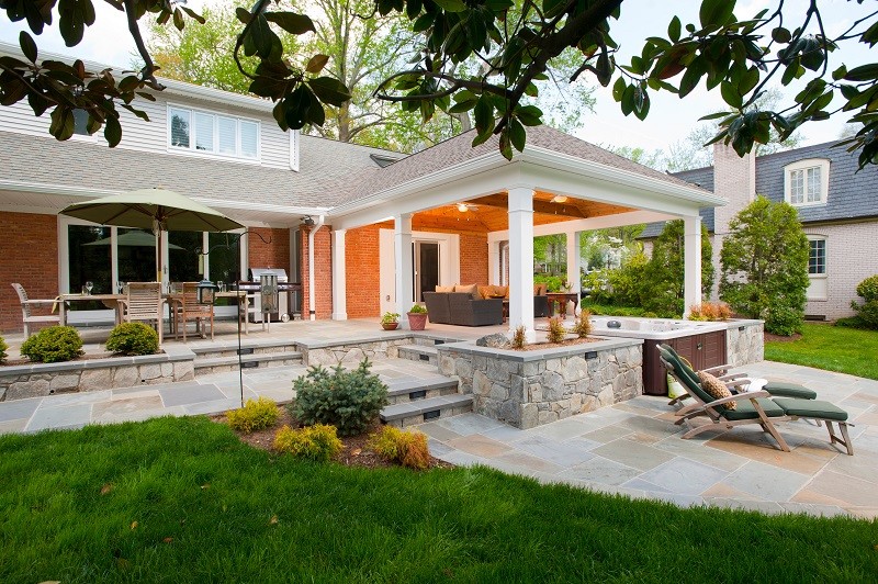 Design ideas for a mid-sized contemporary backyard patio in DC Metro with stamped concrete and a roof extension.