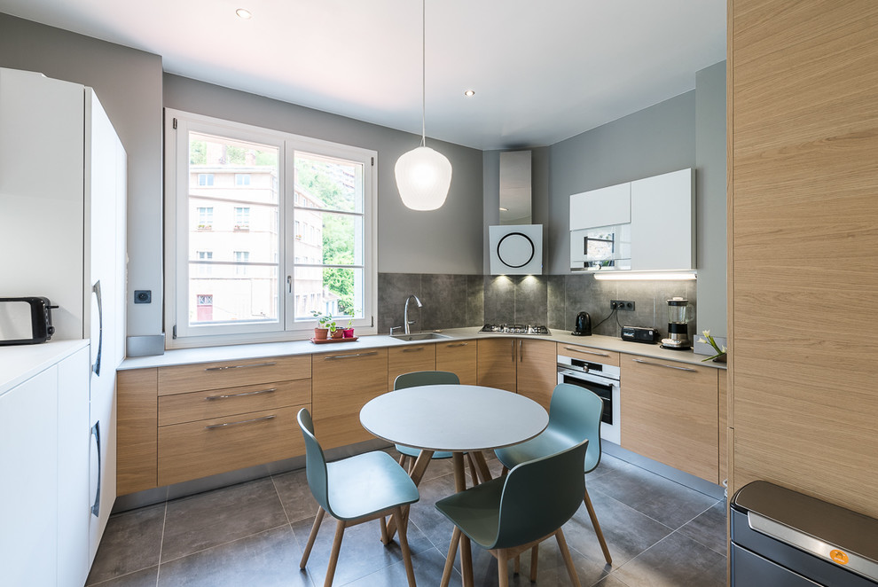 Design ideas for a large contemporary u-shaped separate kitchen in Lyon with an integrated sink, light wood cabinets, quartz benchtops, ceramic splashback, white appliances, ceramic floors, no island, grey floor and flat-panel cabinets.