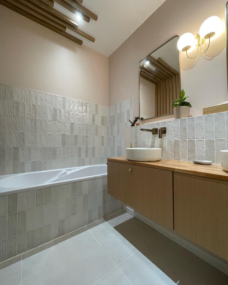 Photo of a large scandinavian master bathroom in Lyon with an undermount tub, white tile, pink walls, a drop-in sink, wood benchtops, a sliding shower screen, a double vanity, a built-in vanity, beaded inset cabinets, light wood cabinets, a two-piece toilet, terra-cotta tile, ceramic floors, beige floor and beige benchtops.