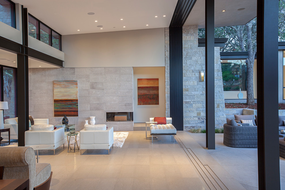 Photo of an expansive contemporary formal open concept living room in San Francisco with beige walls, limestone floors, a two-sided fireplace, a stone fireplace surround, no tv and beige floor.