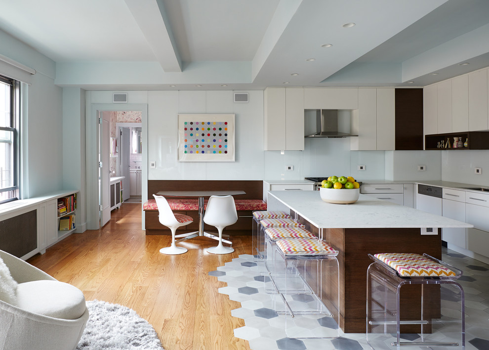 Inspiration for an eclectic l-shaped open plan kitchen in New York with flat-panel cabinets, white cabinets, medium hardwood floors, with island and brown floor.
