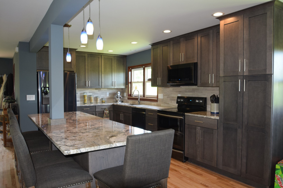 Example of a transitional l-shaped light wood floor eat-in kitchen design with an undermount sink, shaker cabinets, gray cabinets, granite countertops, multicolored backsplash, stone tile backsplash, stainless steel appliances, an island and multicolored countertops