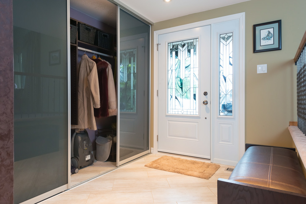 Mid-sized contemporary gender-neutral storage and wardrobe in Ottawa with flat-panel cabinets and travertine floors.